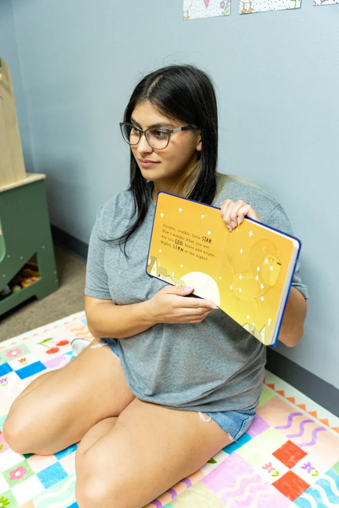Teacher reading a picture book on the classroom rug at The Way PDO